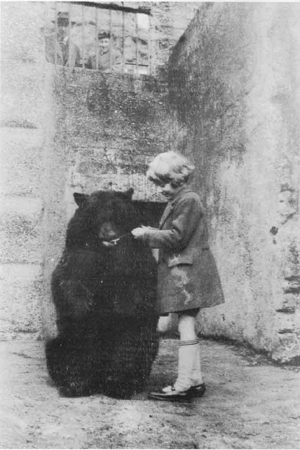 Photo of Christopher Robin with the real Winnie. AA Milne is in the background