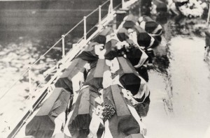 The coffins on board HMS Champion make their way to England